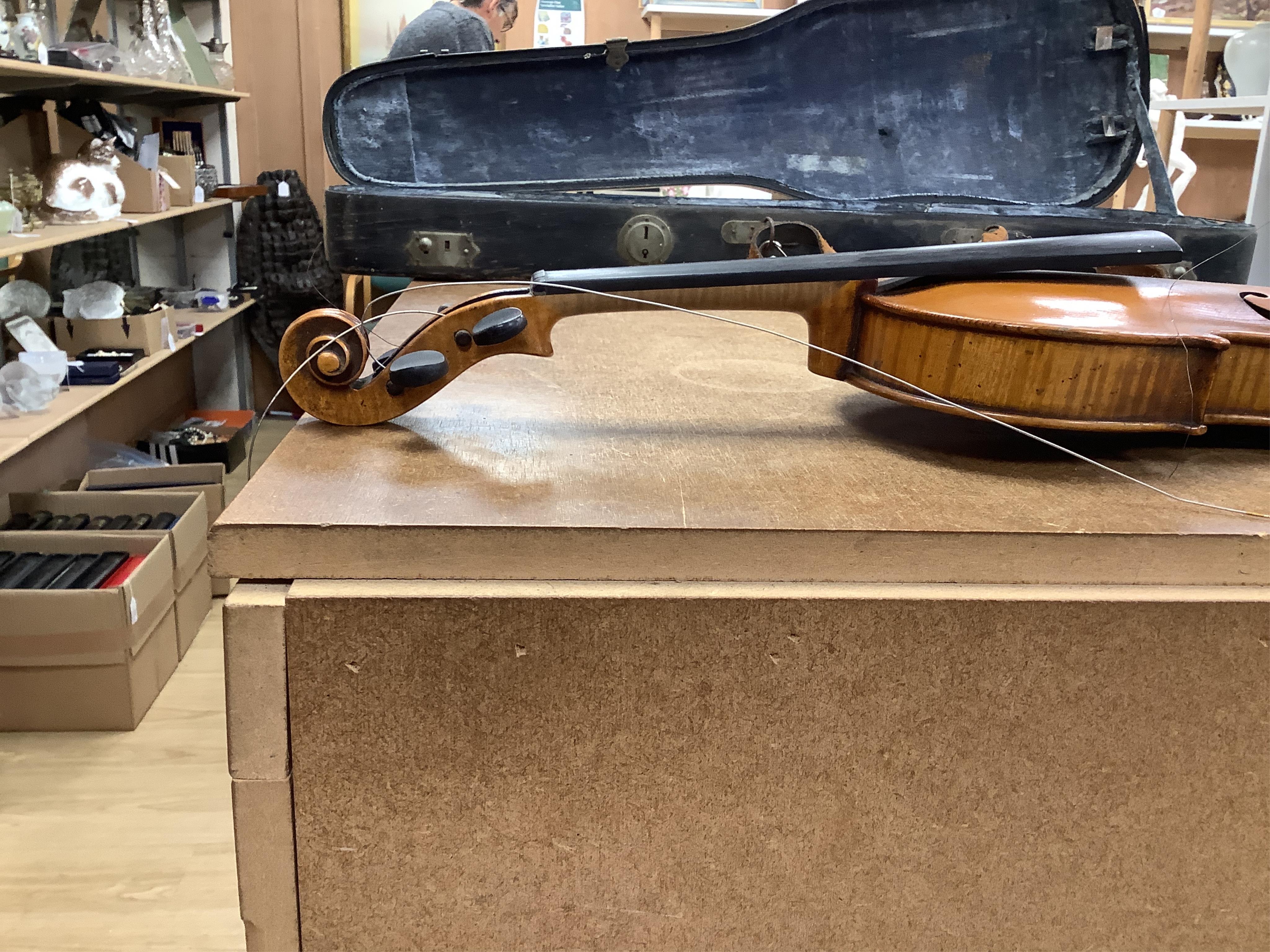 A cased 7/8 size 19th century violin, body 35cm, together with another cased violin, body 35.5cm, both without bows, and a spare case (3)